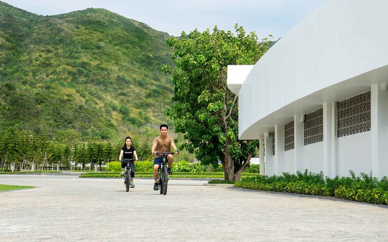 2 khách đang đạp xe trong khuôn viên của Oceanami Villas and Beach Club