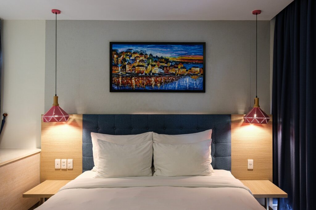 phòng ngủ với giường, đèn ngủ, tranh trang trí tại một villa nghỉ dưỡng
