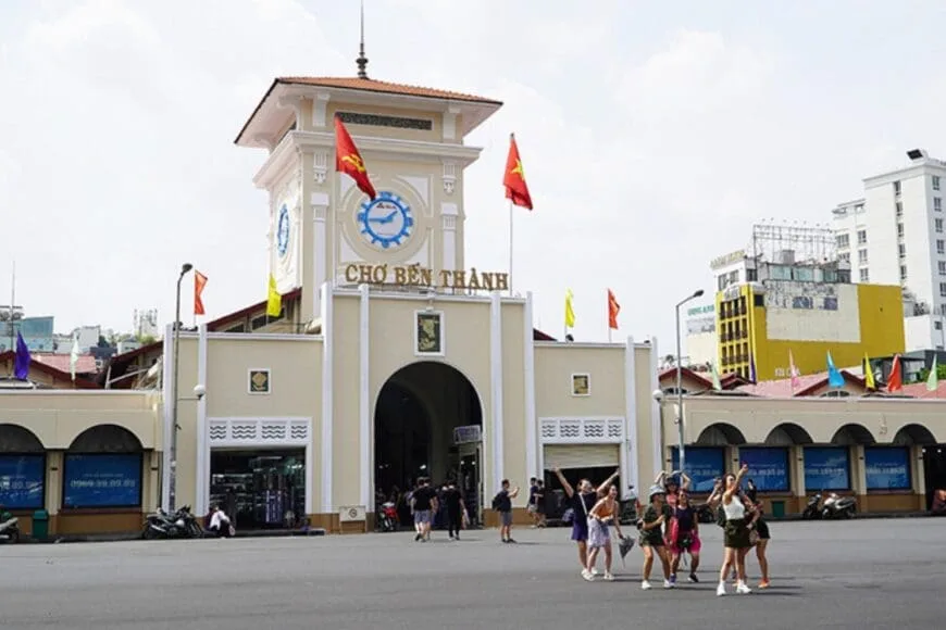 Nhóm người chụp ảnh lưu niệm tại mặt trước chợ Bến Thành