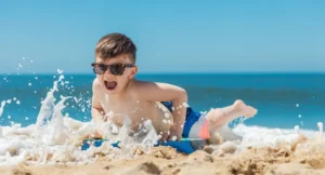 Đứa trẻ hào hứng chơi trên bãi cát khi đi biển